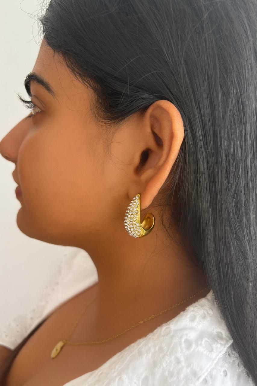 Woman wearing Febae gold crystal hoop earrings in 18K PVD gold
